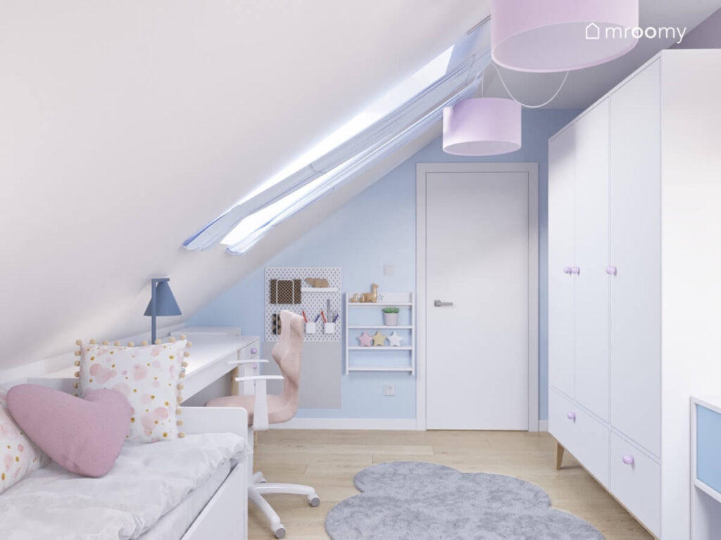 Biało niebieski poddaszowy pokój dla dziewczynki z białym łóżkiem biurkiem oraz szafą a także dywanem w kształcie chmurki