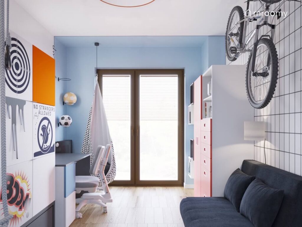 Błękitno biały pokój dla chłopca z kolorowymi meblami fotelem kokonem oraz granatową sofą