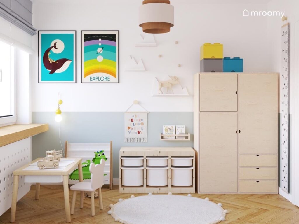 Biało szary pokój dla chłopca z drewnianymi meblami półeczkami w kształcie gór oraz kolorowymi plakatami