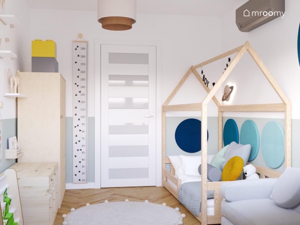 Biało szary pokój dla małego chłopca a w nim drewniane meble łóżko domek oraz miarka wzrostu