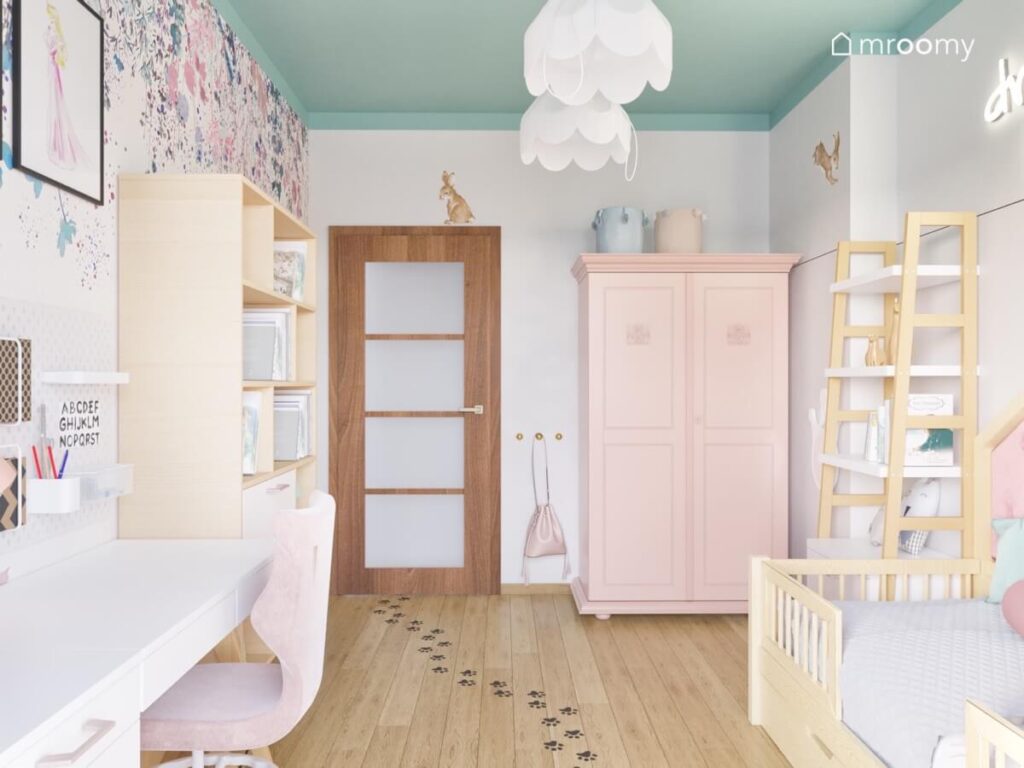 Biało miętowy pokój dla dziewczynki a w nim drewniane meble kwiecista tapeta oraz lampy bezy