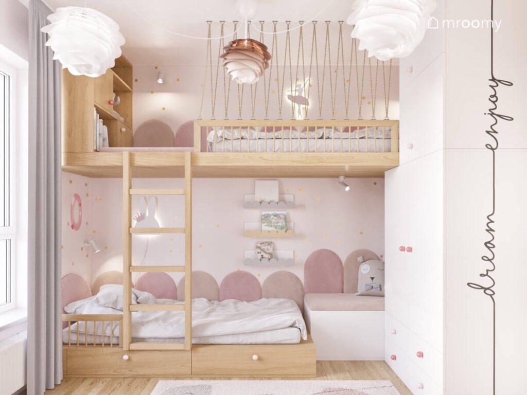 Strefa spania w pokoju dwóch sióstr a w niej łóżko na drewnianej antresoli oraz drugie drewniane łóżko oba uzupełnione różowymi panelami i lampkami nocnymi