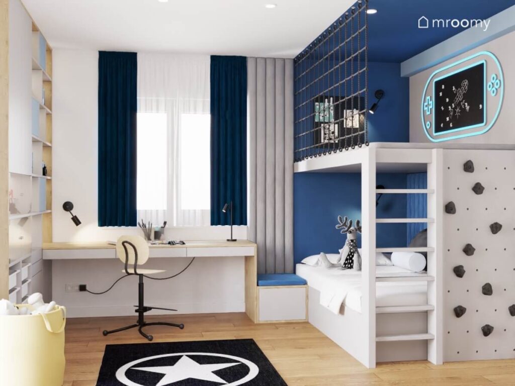 Jasny pokój dla chłopca z białą strefą nauki z biało drewnianym biurkiem i niebieską strefą spania z antresolą