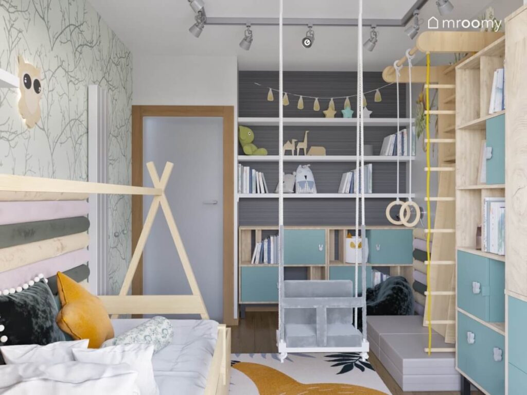 Drewniane łóżko tipi huśtawka wisząca oraz drewniano niebieskie meble w pokoju dziewczynki