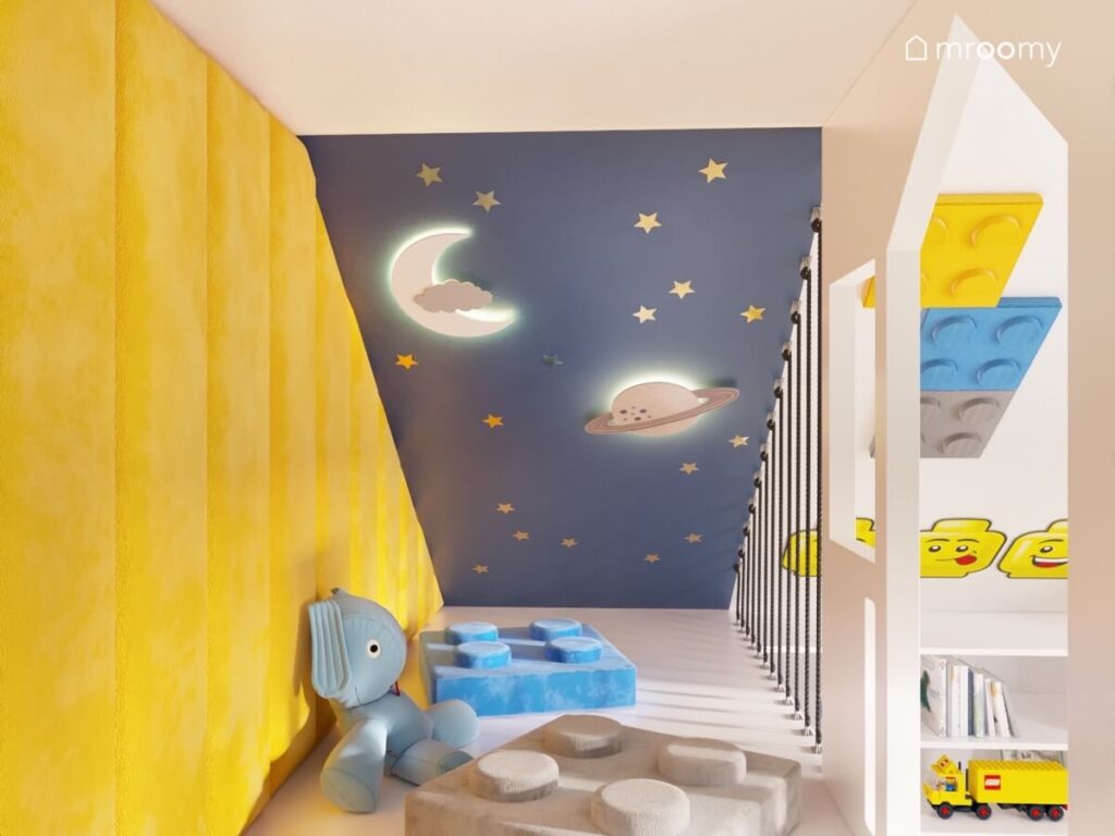 Piętro antresoli w pokoju chłopca wyłożone żółtymi panelami z pufkami w kształcie klocków i kosmicznym skosem