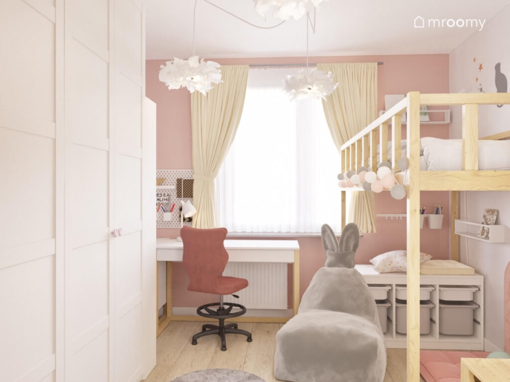 Przytulny pokój dla dziewczynki z dużą białą szafą biało drewnianym biurkiem drewnianą antresolą oraz szarą pufą z uszami