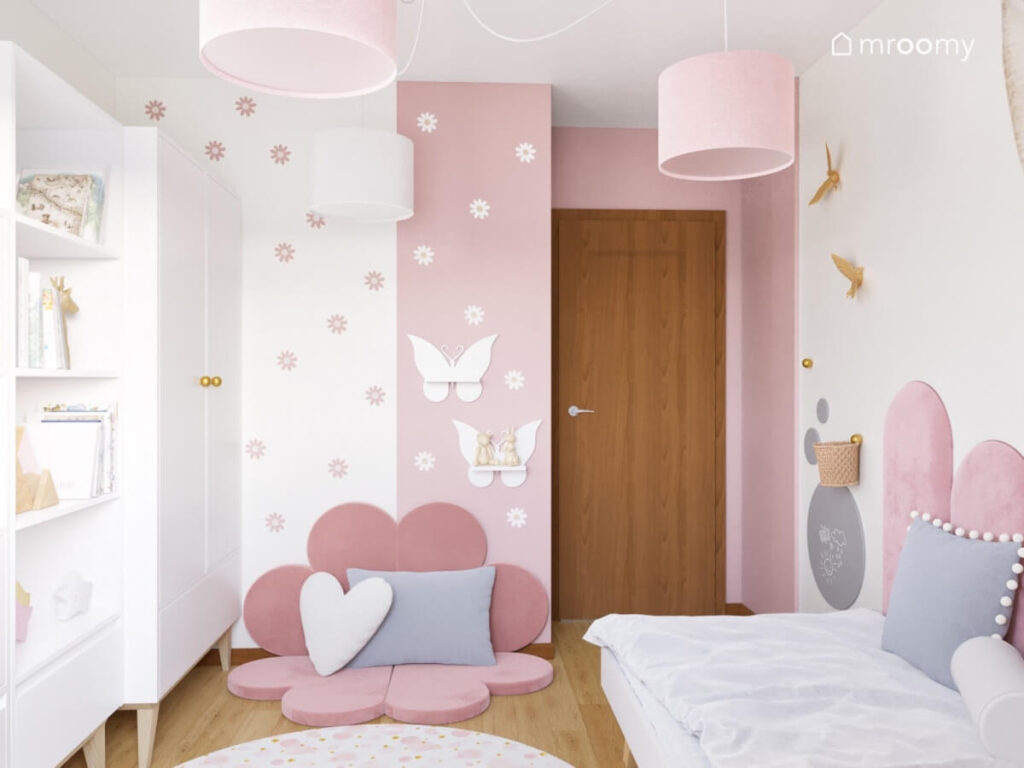 Biało różowy pokój dla dziewczynki z ozdobami w postaci kwiatków ptaków i motyli na ścianach oraz z miękkimi różowymi panelami