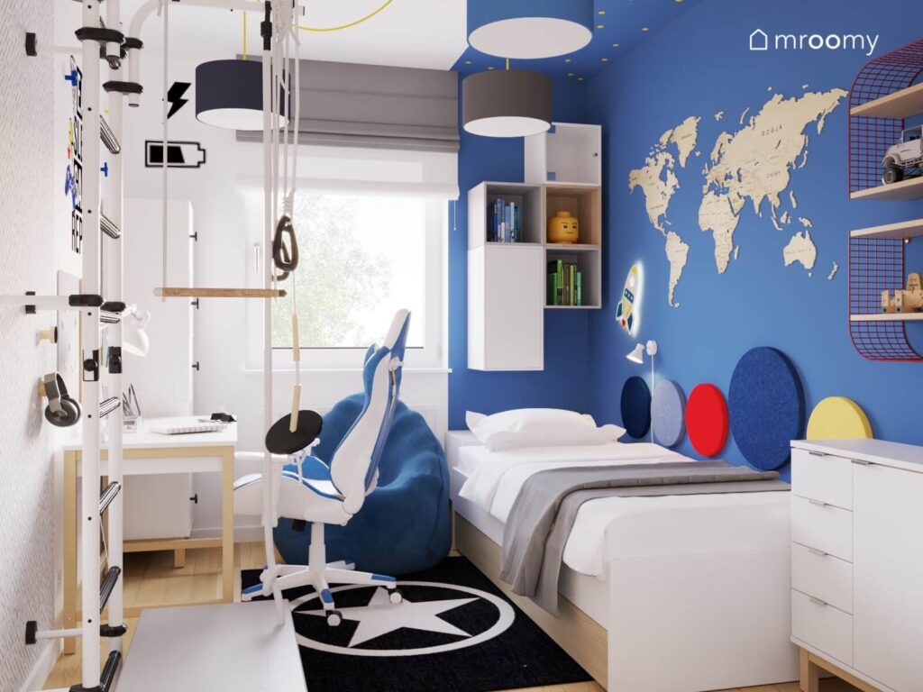 Biało niebieski pokój dla chłopca z białymi meblami mapą świata oraz niebieską pufą