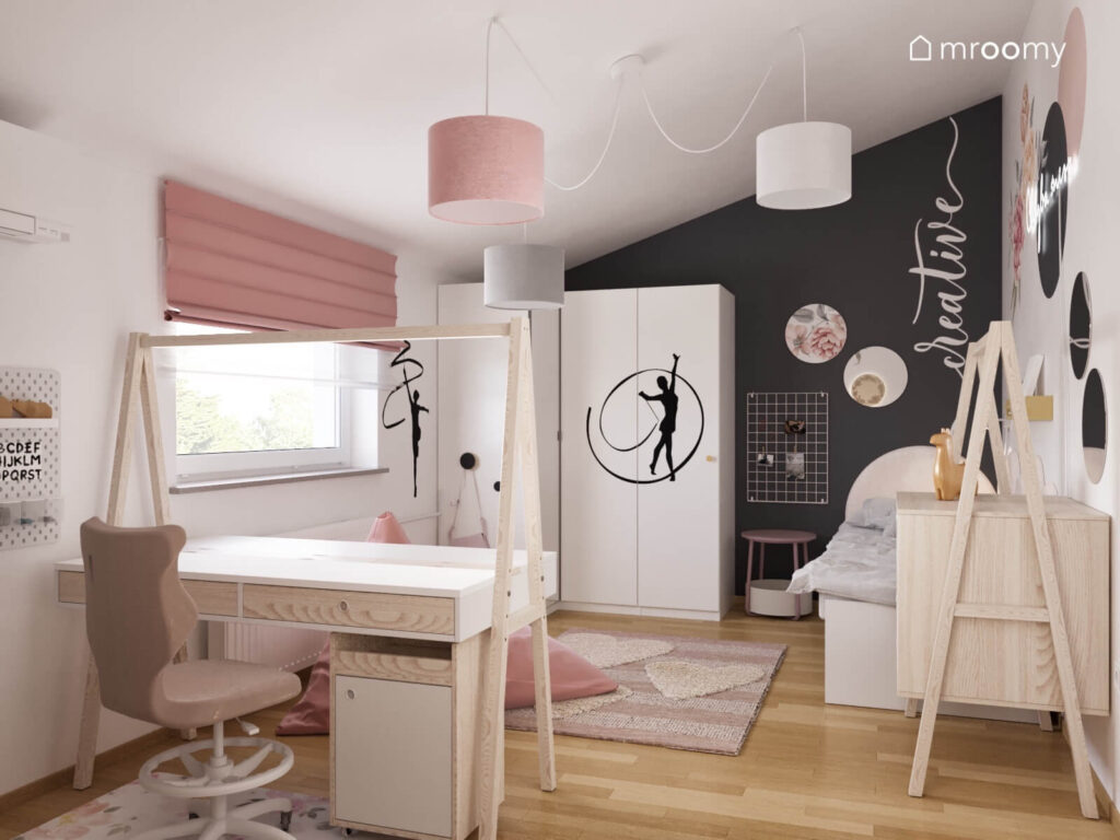Biały poddaszowy pokój dziewczynki z biało drewnianymi meblami różowymi dodatkami i jedną grafitową ścianą