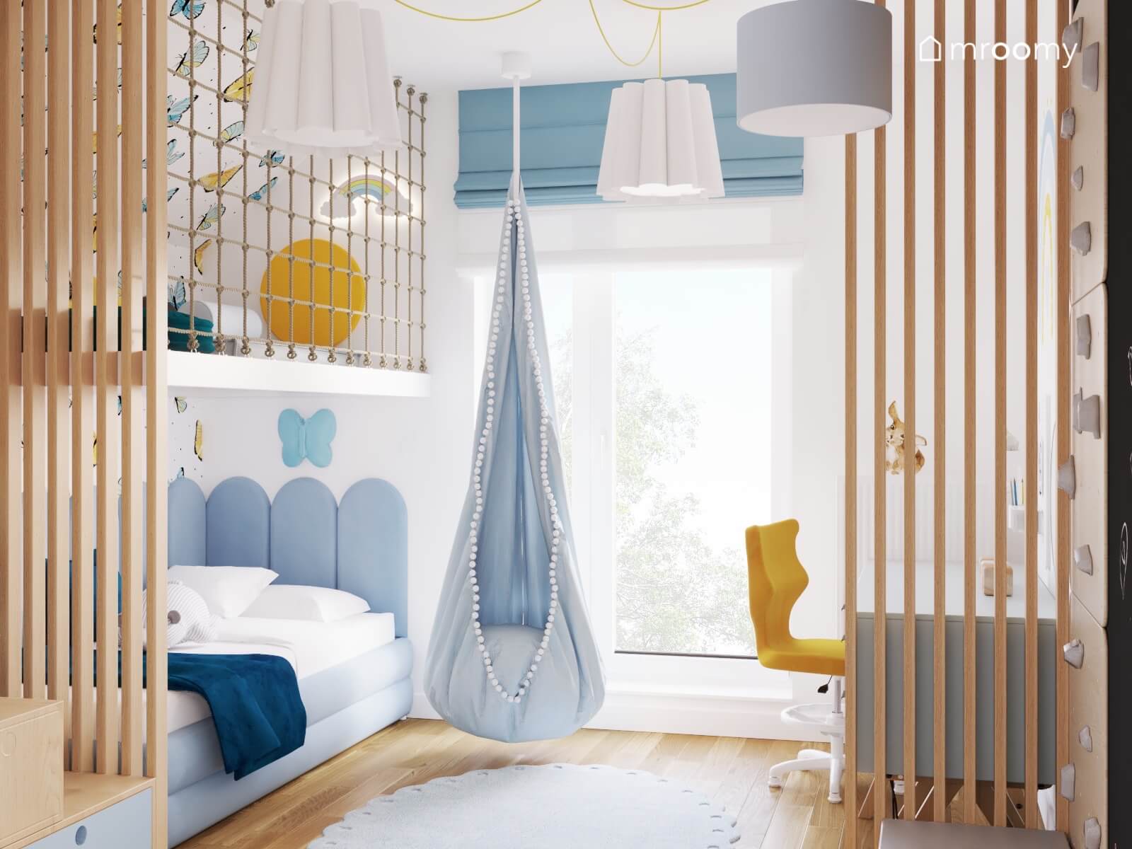 Jasny pokój dla dziewczynki z antresolą z miejscem do zabawy fotelem kokon oraz błękitnymi i żółtymi dodatkami