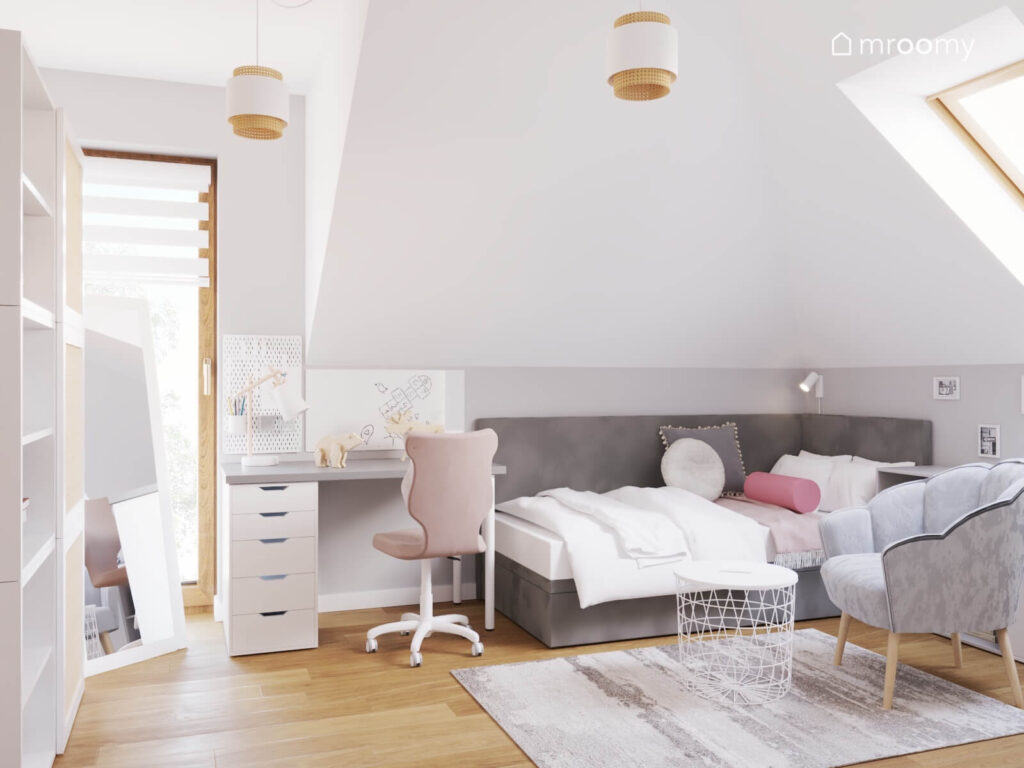 Biały poddaszowy pokój dziewczynki z szarym tapicerowanym łóżkiem i małym biurkiem z organizerami