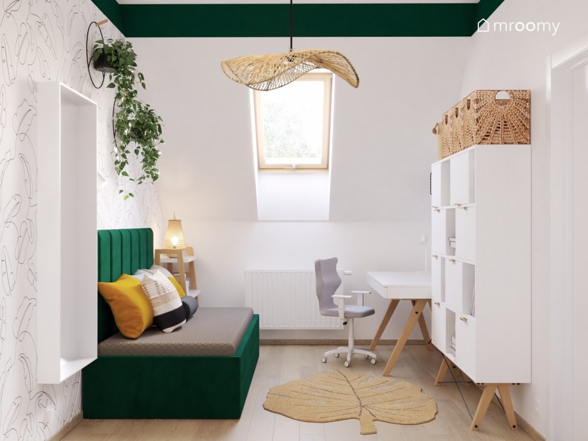 Biały poddaszowy pokój dla nastolatki z zielonym tapicerowanym łóżkiem oraz białymi meblami na drewnianych nogach