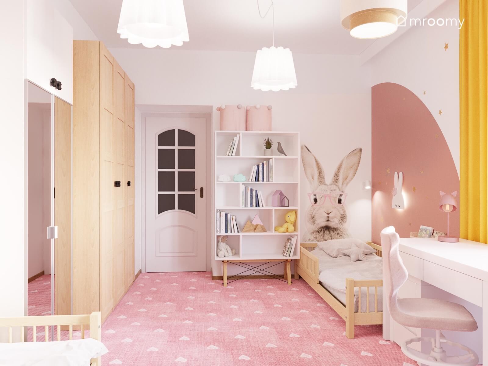 Biało różowy pokój dla dwóch sióstr z drewnianymi łóżkami szafą i wysokim regałem a na ścianie naklejka królik